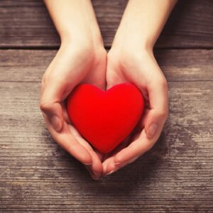 person holding red heart in two hands